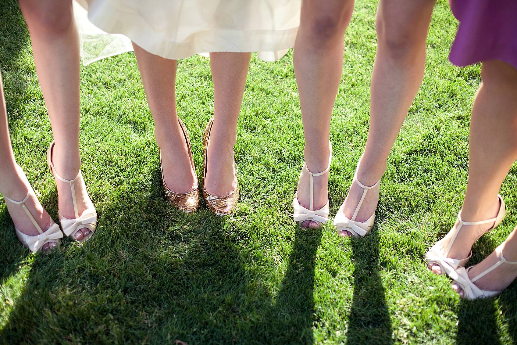 bride in j.crew dress and kate spade gold sparkle shoes with sunlight behind