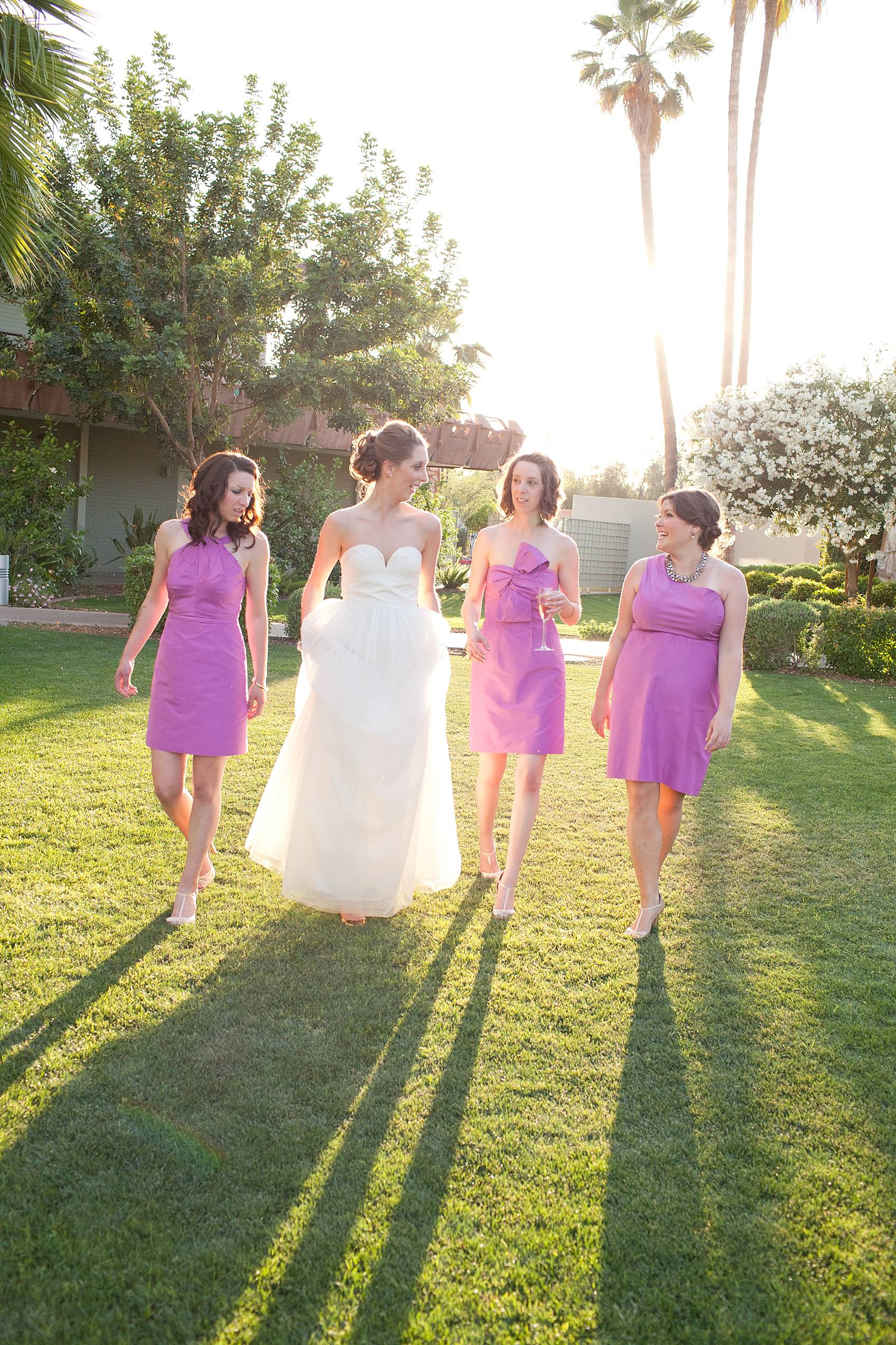 bride in j.crew bridal dress with bridal party walking with sun behind them