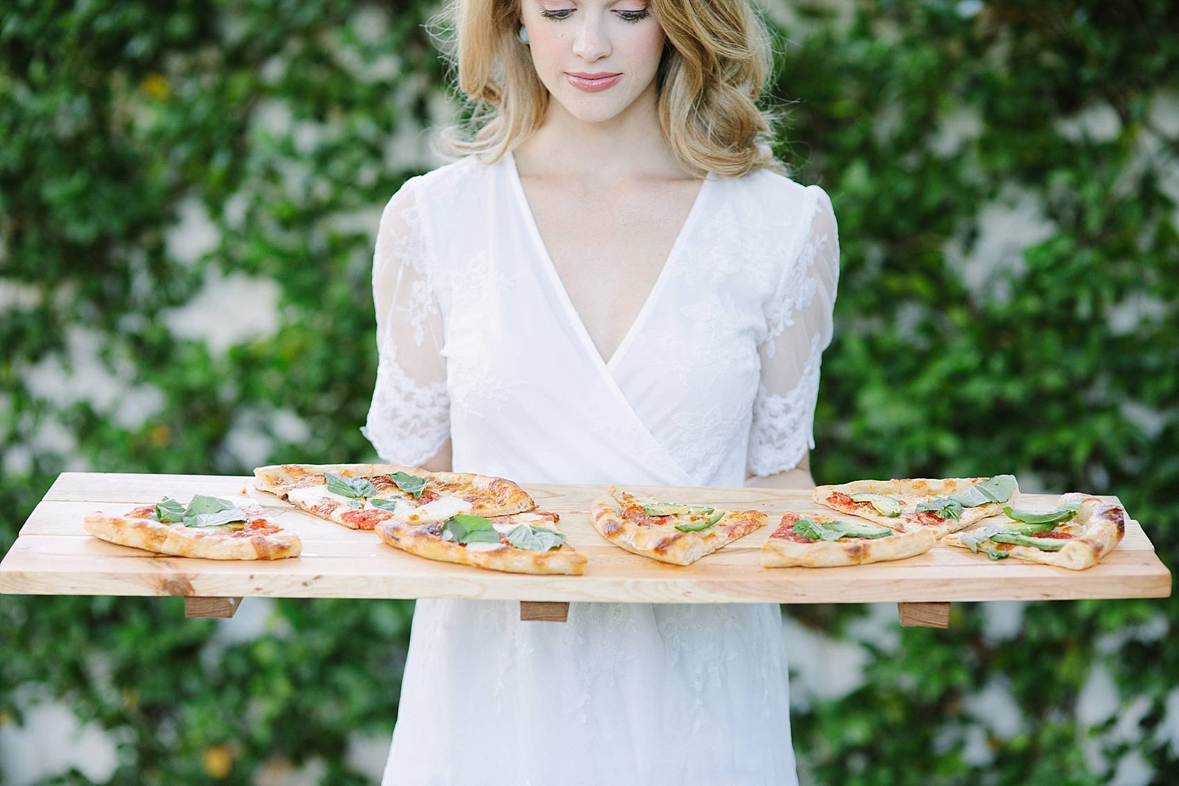 woman holding wood board with pizza