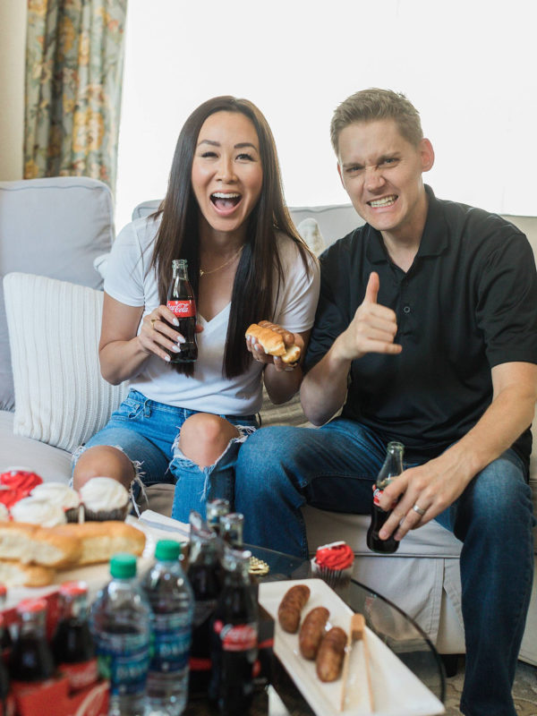 lifestyle blogger diana Elizabeth with husband on couch watching football - football party Coke Zero tailgating at home party setup ideas