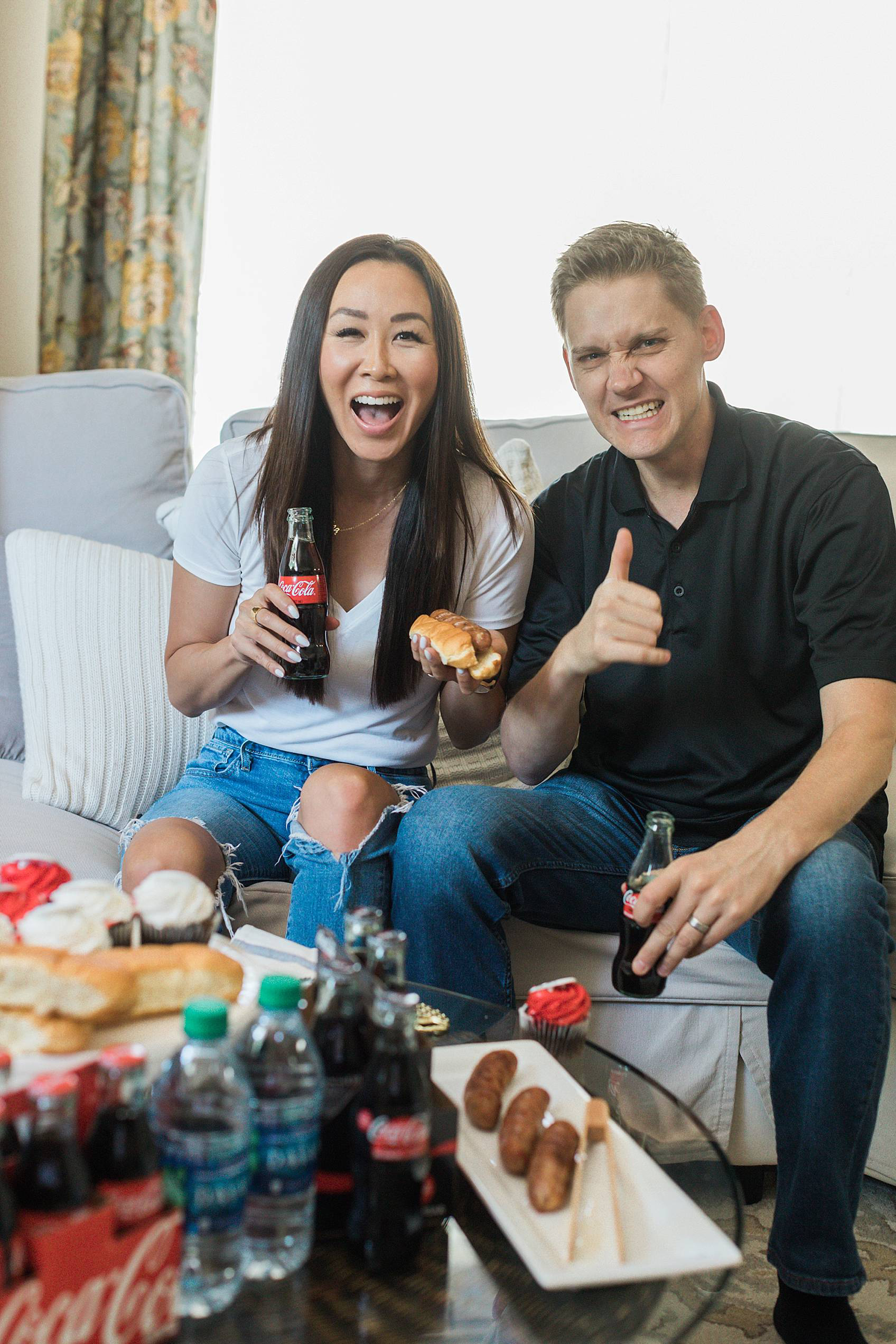 lifestyle blogger diana Elizabeth with husband on couch watching football - football party Coke Zero tailgating at home party setup ideas
