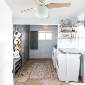 laundry mud room with custom cabinets rustic look with blue removable wallpaper in background and mint hunter fan