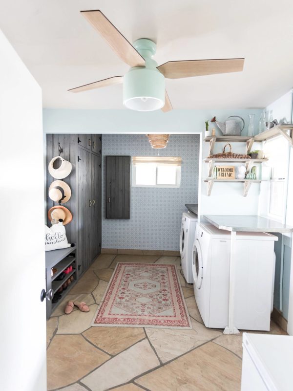 laundry mud room with custom cabinets rustic look with blue removable wallpaper in background and mint hunter fan