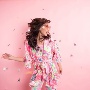 Lilly Pulitzer Christmas pajama party Diana Elizabeth in front of pink background and star confetti