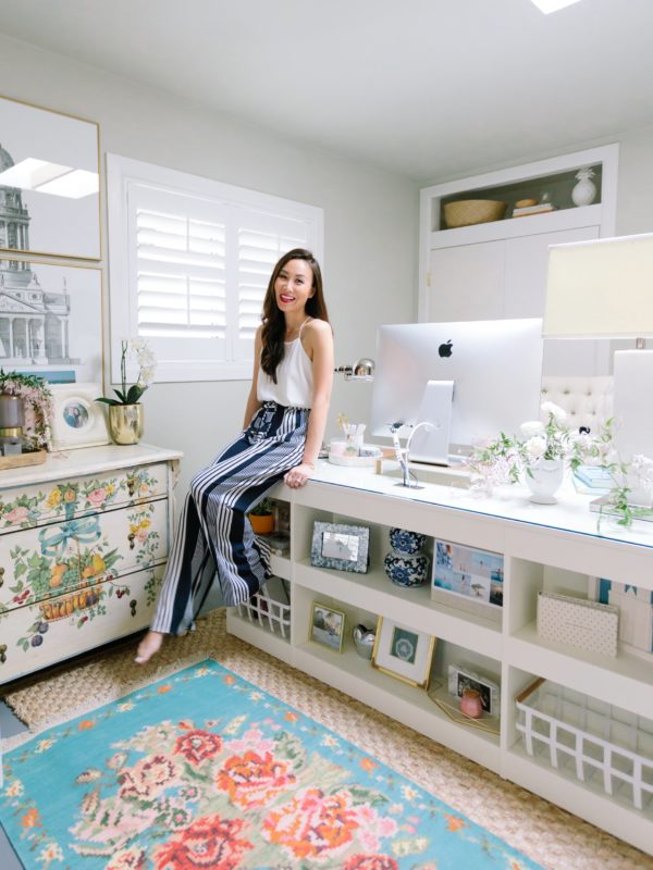 blogger photographer home office decor Diana Elizabeth - wearing white top with blue and white stripe pants sitting on Coastal Living by Stanley Furniture Oasis Cape Dutch Writing Desk