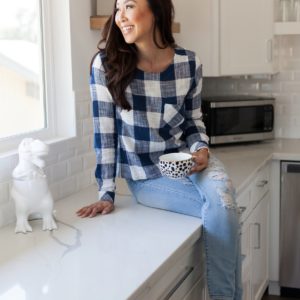 Diana Elizabeth in blue white gingham top on kitchen counter
