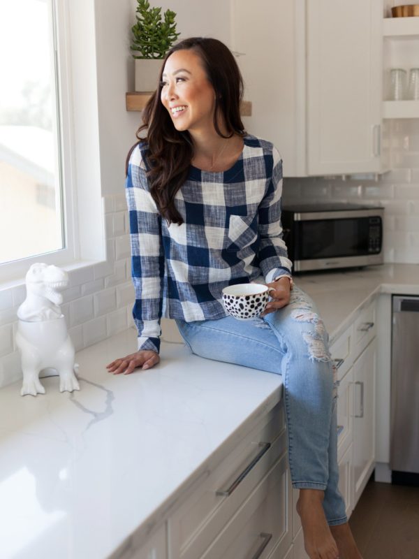 Diana Elizabeth in blue white gingham top on kitchen counter