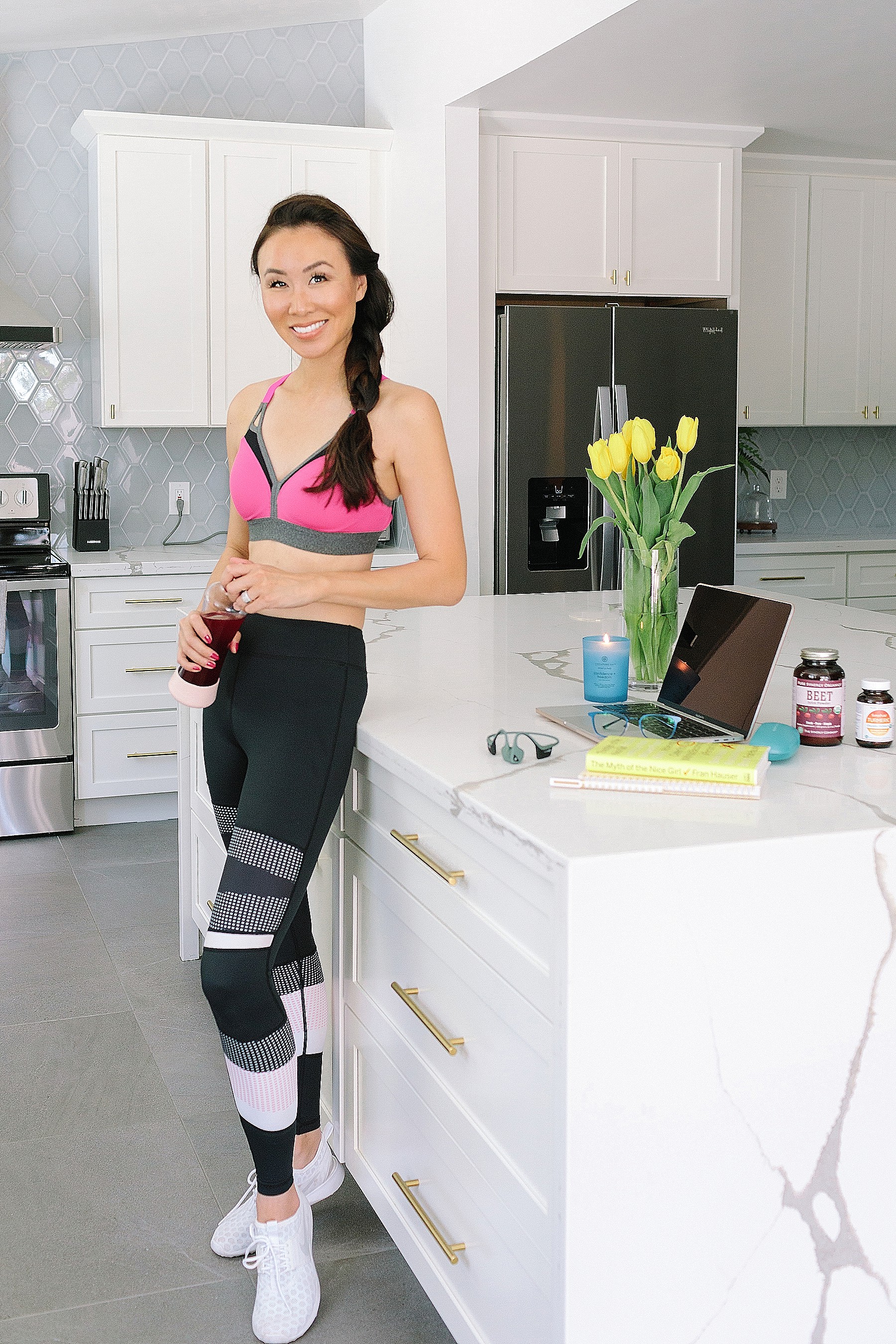 Women's wellness product reviews with lifestyle blogger Diana Elizabeth - post workout standing in kitchen with water bottle