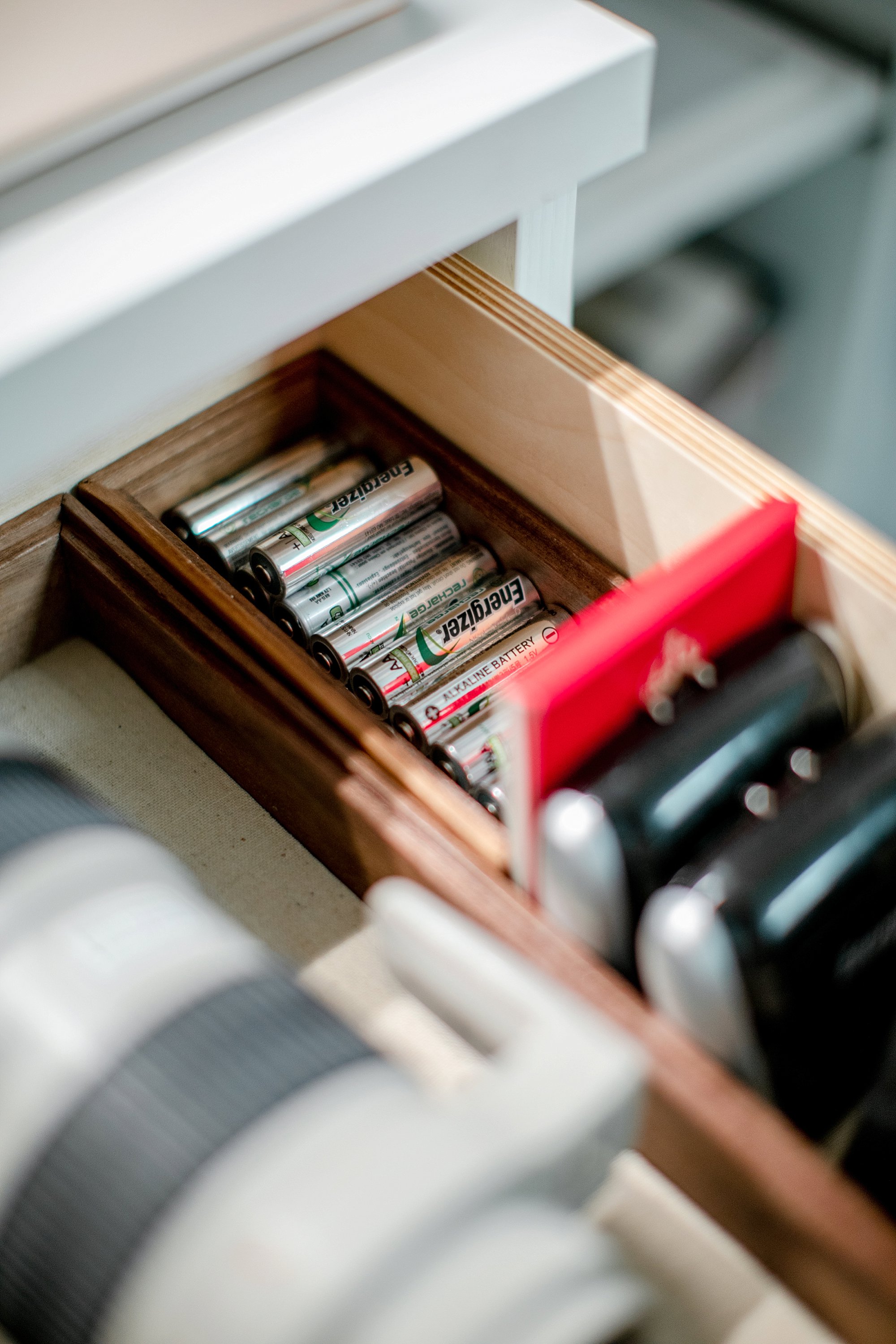 organizing for a photographer's camera lenses and batteries in an office closet drawer with removable wallpaper check out the reveal on the blog post #office #closet #camera