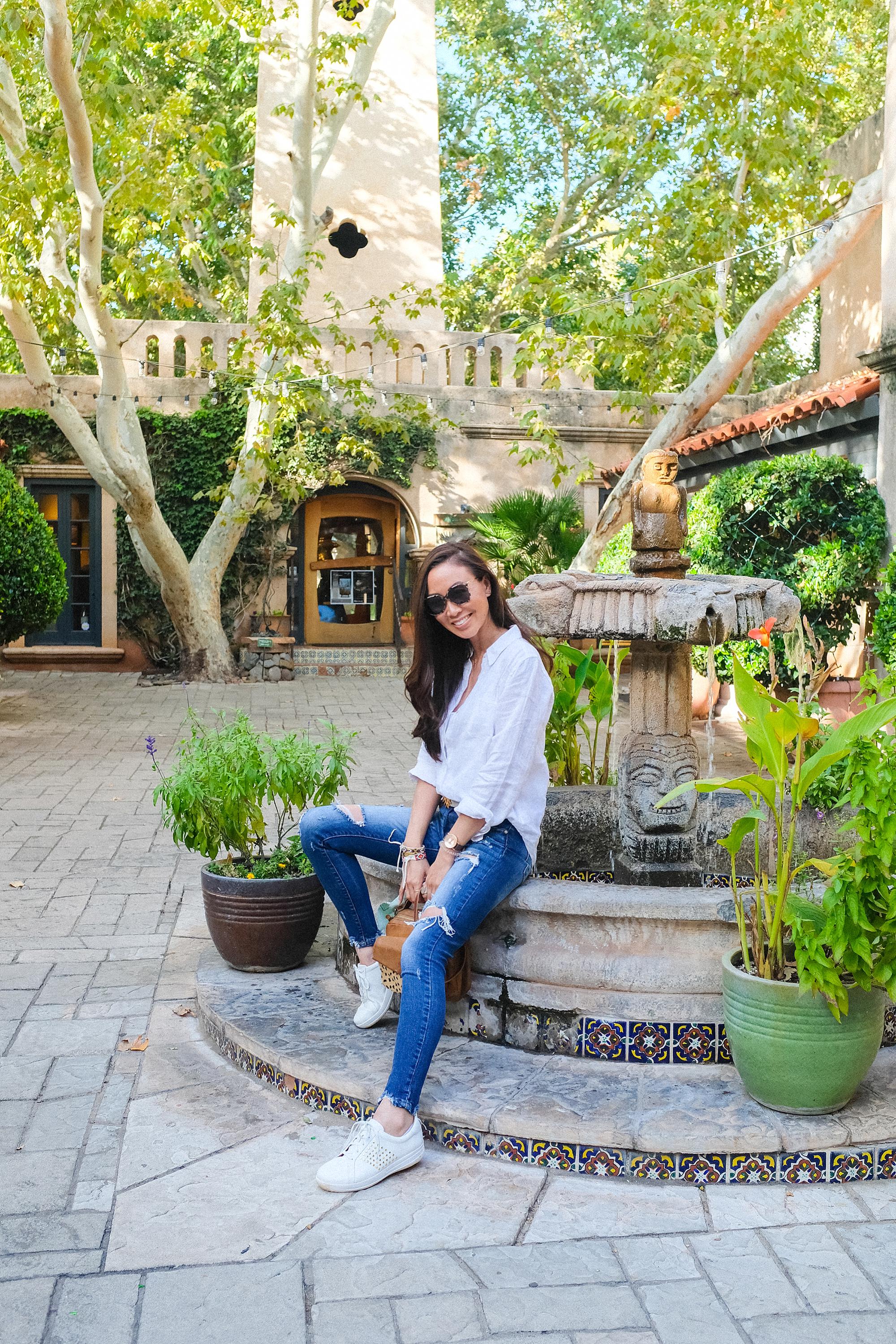 Tlaquepaque Arts & Crafts Village shopping in Sedona, lifestyle blogger Diana Elizabeth wearing white sneakers by fountain