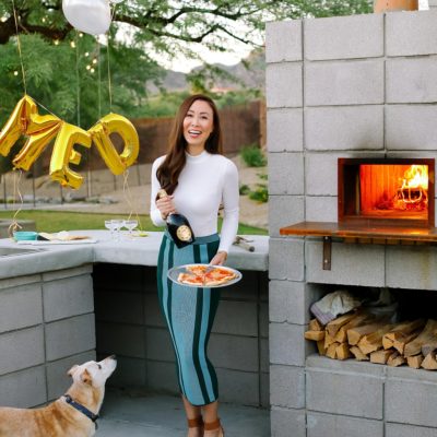 santa margherita prosecco superiore set by mylar alphabet balloons and the an outdoor pizza fireplace lifestyle blogger Diana Elizabeth in phoenix arizona holding pizza