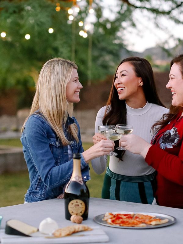 santa margherita prosecco superiore set by mylar alphabet balloons and the an outdoor pizza fireplace lifestyle blogger Diana Elizabeth in phoenix arizona toasting with friends