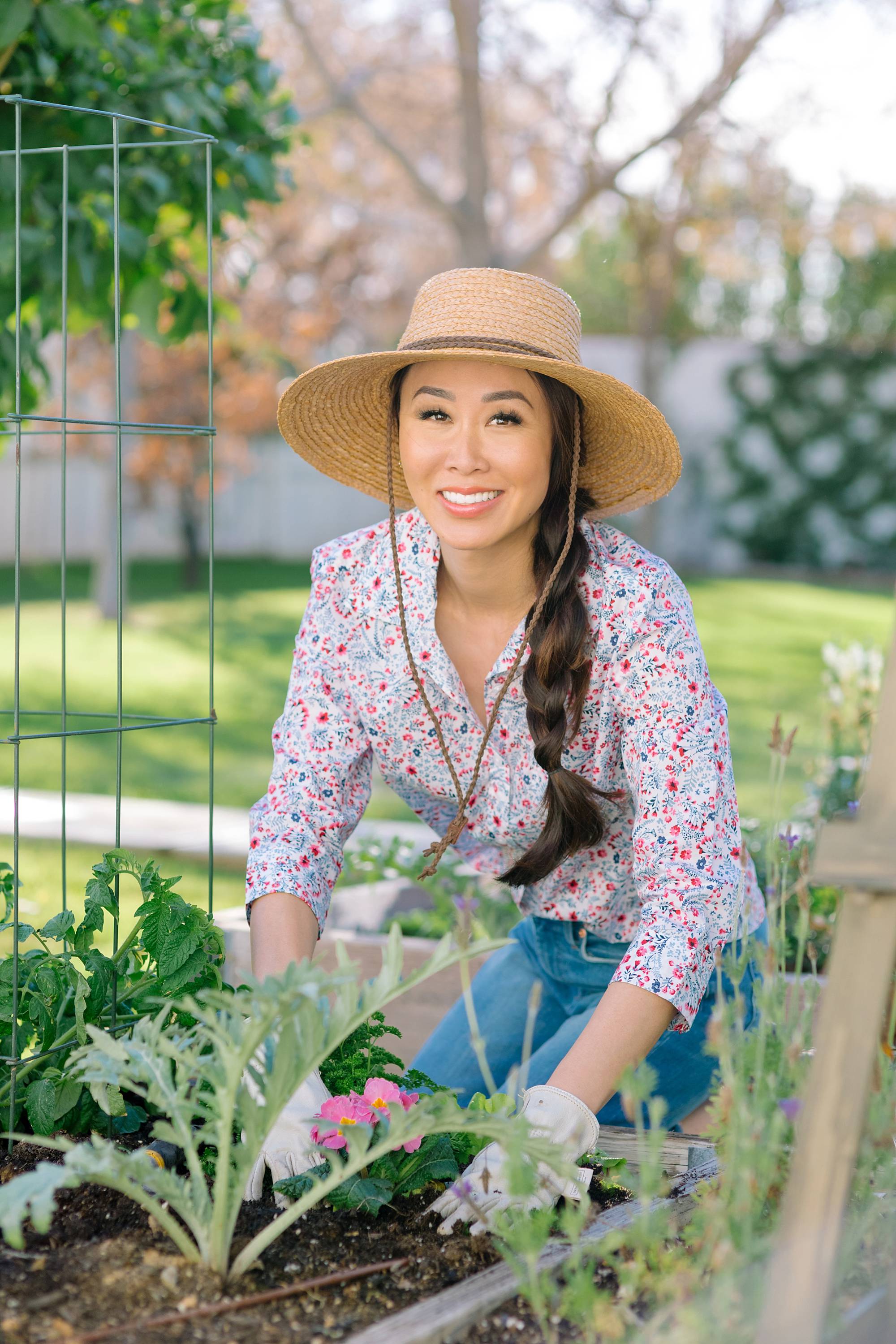 garden lifestyle blogger Diana Elizabeth in backyard garden raised garden beds in phoenix arizona wearing floral print shirt