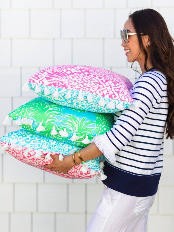 Lilly Pulitzer x Pottery Barn collaboration Spring summer 2019 carrying pile of lilly Pulitzer outdoor pillows