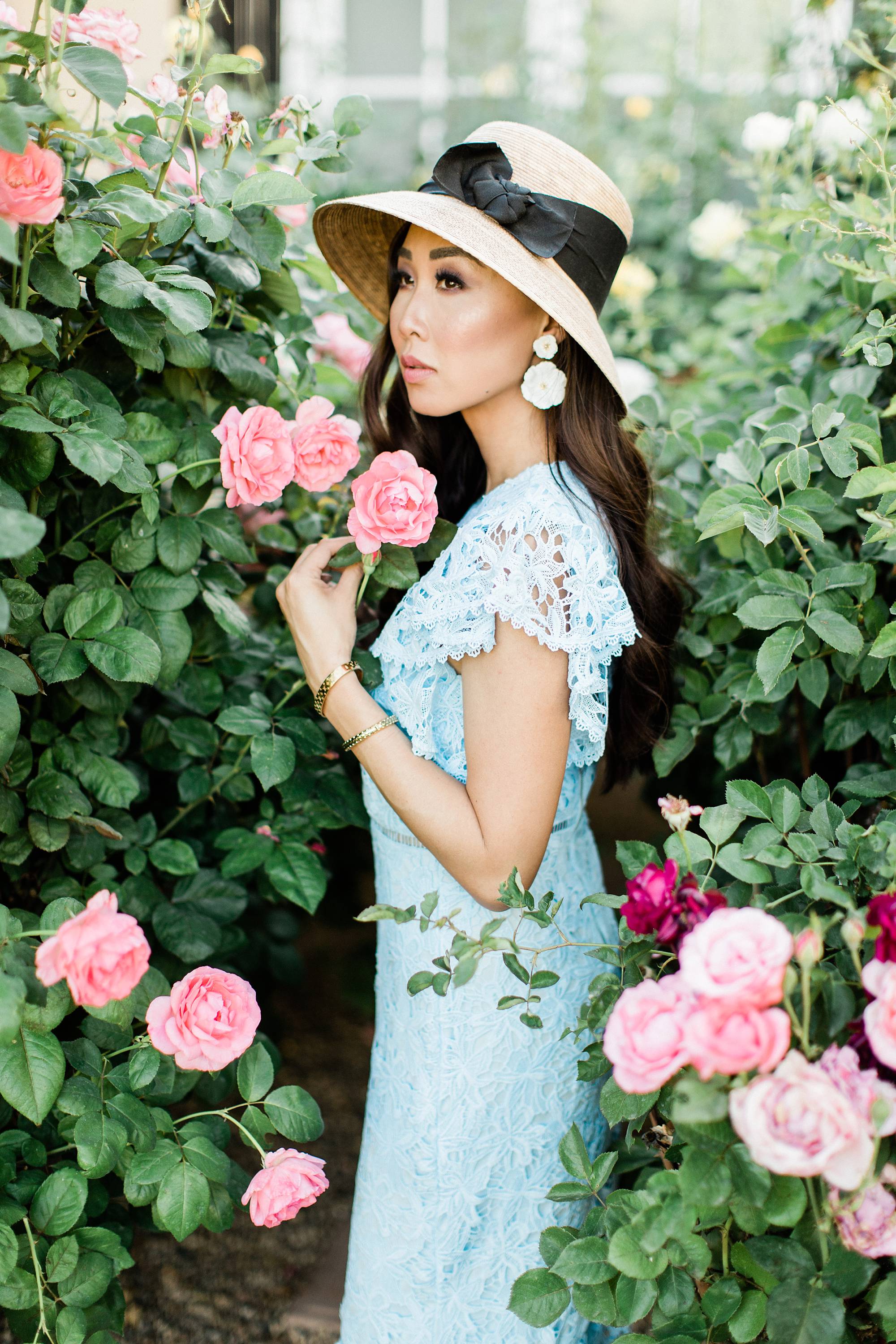blue lace dress with garden hat from terrain nestled between pink roses