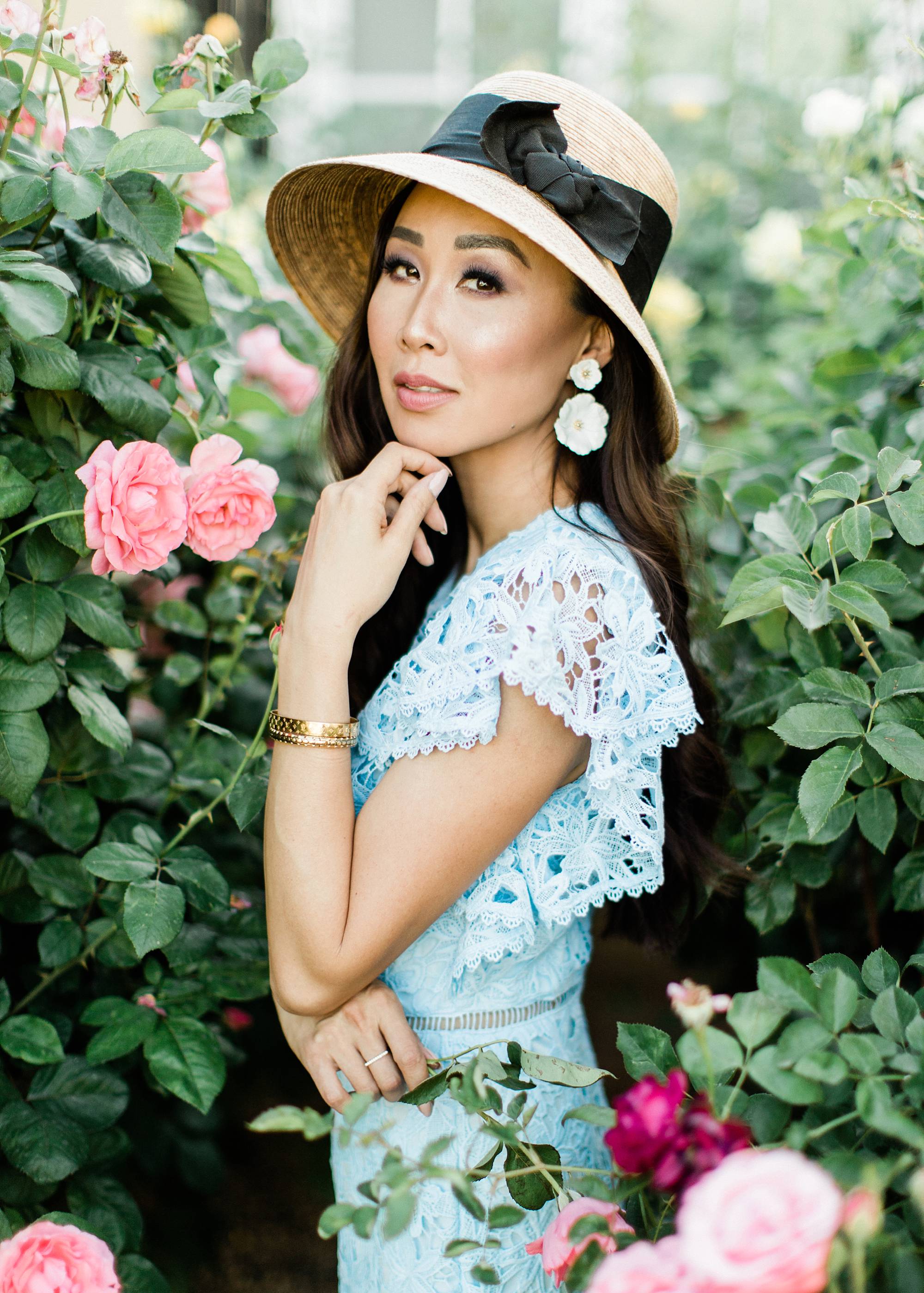 blue lace dress with garden hat from terrain nestled between pink roses against the wall - lifestyle blogger Diana Elizabeth phoenix scottsdale arizona