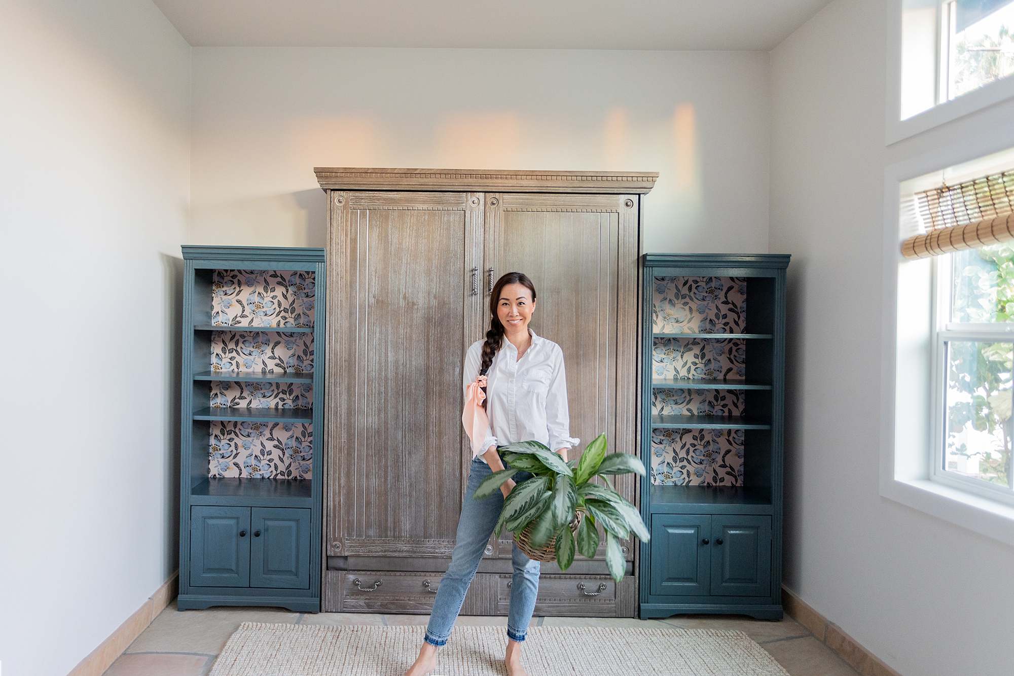 phoenix home blogger Diana Elizabeth in front of Murphy bed with bookshelves and wallpaper