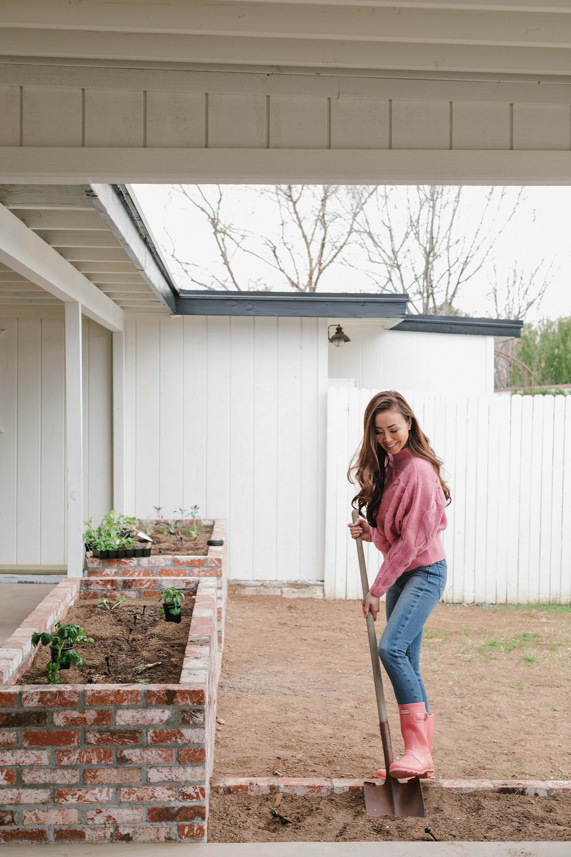 arizona Phoenix Arizona blogger Diana Elizabeth in pink sweater and pink hunter boots gardening 