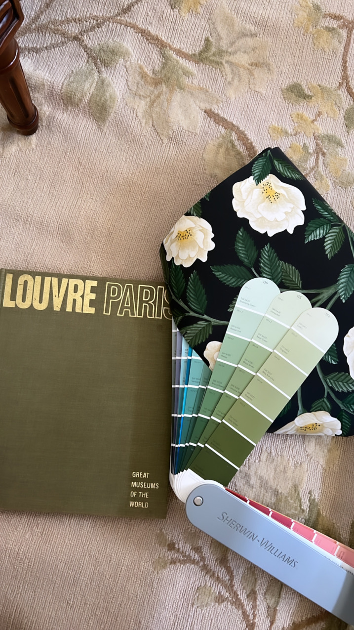 green paint swatches against Cole and sons wallpaper and "the Louvre" book