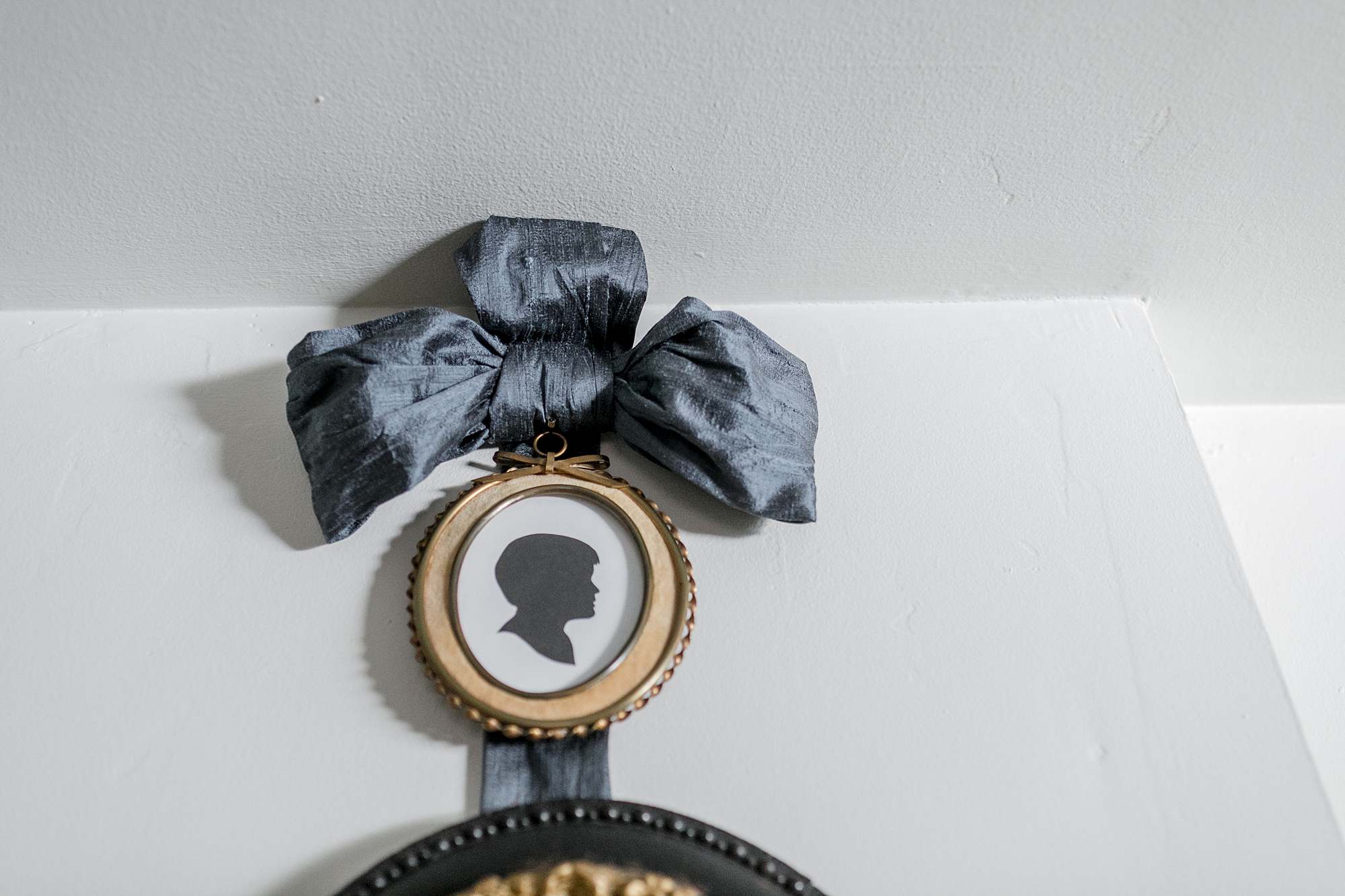 bow and silhouette in an oval frame hanging on mantle 